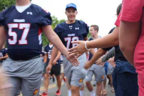 The football boys give high fives during the parade