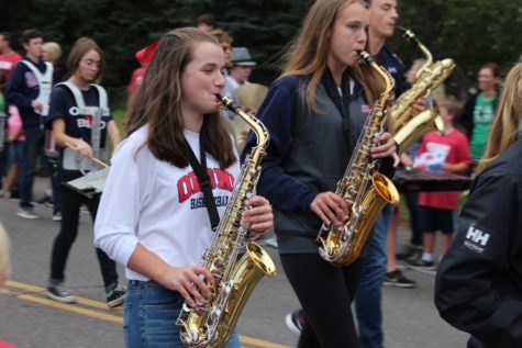 Sophomore Jordan Case and junior Anna Hughes play the saxophone in the parade