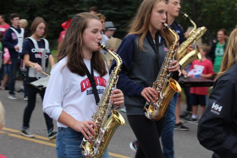 Sophomore Jordan Case and junior Anna Hughes play the saxophone in the parade