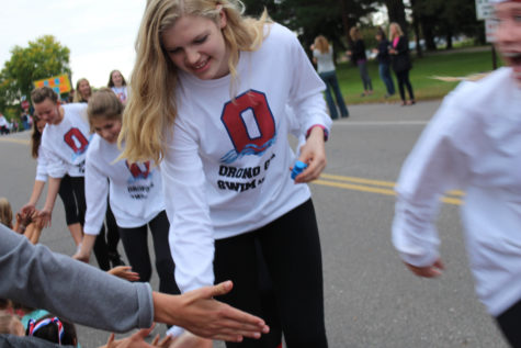 Spartan swim and dive girls high five the crowd as they go by