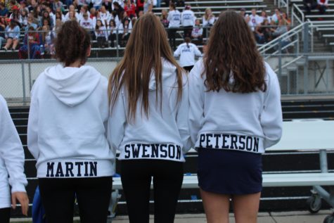 The tennis girls wearing their new sweatshirt watch the crowd