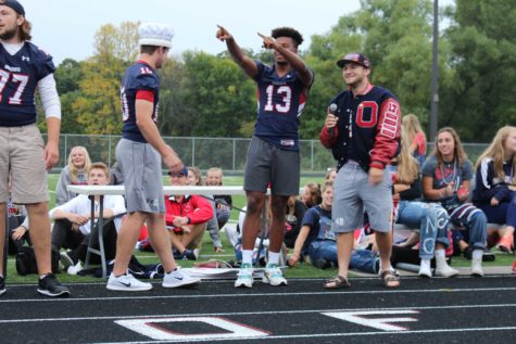 Senior football captain points to the rest of the team looking for a cheer