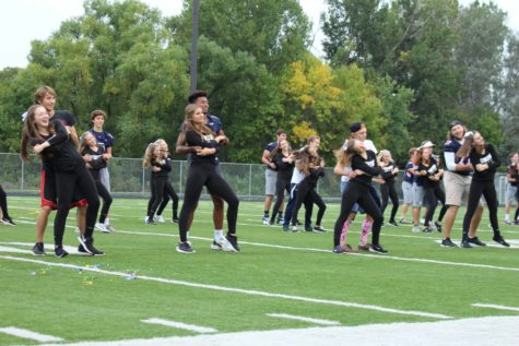 The dance team dances with the football and soccer boys