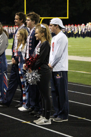 Members of the Homecoming court stand on the track at halftime.