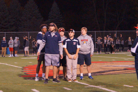 Senior coaches stand a center field. 