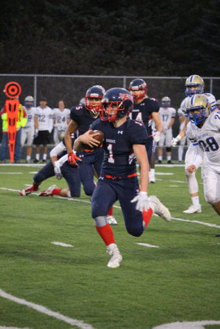 Sophomore quarterback Nick Prentice runs the ball down the field on Homecoming night against Holy Angels. 