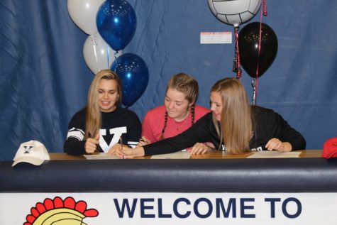Seniors Tori Andrew, Megan Anderson, and Sam Fischer look on as Tori begins to sign her letter