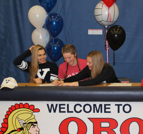 Seniors Tori Andrew, Sam Fischer, and Will Brenton laugh together during the signing